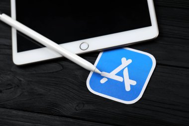 KHARKIV, UKRAINE - 27 Ocak 2021: Yepyeni Apple iPad ve Apple kalem ve siyah arkaplanda mavi uygulama mağaza logosu. Apple Inc. merkezi Kaliforniya 'da bulunan bir Amerikan teknoloji şirketidir.