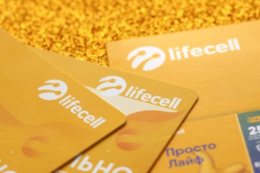 TERNOPIL, UKRAINE - JULY 5, 2022: Lifecell new sim card with free contract on yellow background. Lifecell is ukrainian mobile telephone network operator and provider of wireless internet connection