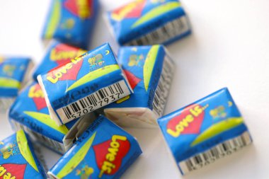 TERNOPIL, UKRAINE - JUNE 23, 2022: Love is - turkish bubble gums from 1990s popular in russian region. Various flavors of Love is chewing gum with liners about love in pile