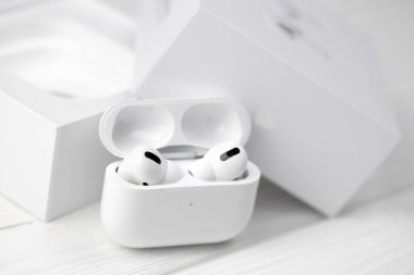 KHARKIV, UKRAINE - 27 Ocak 2021: Apple AirPods Pro beyaz arka planda. Kablosuz kulaklık, şarj çantası ve bir kutu. Apple Inc. merkezi Kaliforniya 'da bulunan bir Amerikan teknoloji şirketidir.