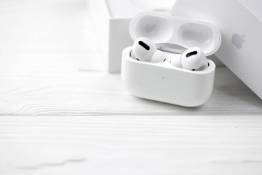 KHARKIV, UKRAINE - 27 Ocak 2021: Apple AirPods Pro beyaz arka planda. Kablosuz kulaklık, şarj çantası ve bir kutu. Apple Inc. merkezi Kaliforniya 'da bulunan bir Amerikan teknoloji şirketidir.