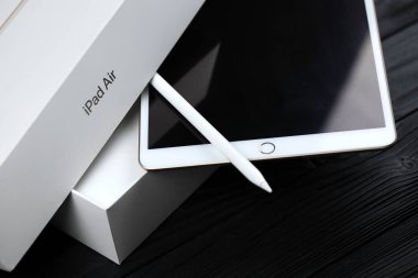 KHARKIV, UKRAINE - JANUARY 27, 2021: Brand new Apple iPad and Apple Pencil on black background. Apple Inc. is an American technology company headquartered in California