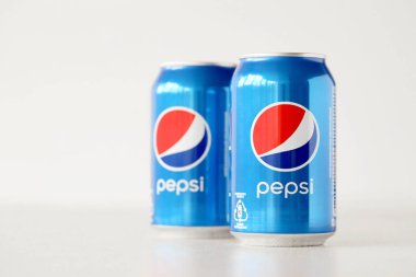 TERNOPIL, UKRAINE - MAY 28, 2022: Cold Pepsi drink cans om white background. Pepsi is a carbonated soft drink produced by PepsiCo since 1893