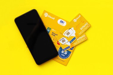 TERNOPIL, UKRAINE - 5 Temmuz 2022: Sarı arka planda ücretsiz sözleşmeli Lifecell yeni simülasyon kartı. Lifecell Ukraynalı cep telefonu operatörü ve kablosuz internet bağlantısı sağlayıcısı