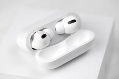 KHARKIV, UKRAINE - 27 Ocak 2021: Apple AirPods Pro beyaz arka planda. Kablosuz kulaklık, şarj çantası ve bir kutu. Apple Inc. merkezi Kaliforniya 'da bulunan bir Amerikan teknoloji şirketidir.