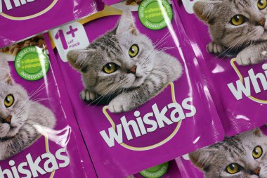 KHARKIV, UKRAINE - FEBRUARY 06, 2021: Whiskas branded cat pet food purple packages close up. Whiskas is a global brand of cat food produced by the American company Mars, Inc