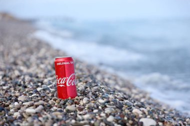 ANTALYA, TURKEY - 18 Mayıs 2021: Orijinal Coca Cola kırmızı teneke kutu deniz kıyısına yakın küçük yuvarlak çakıl taşları üzerinde yatar. Türk plaj taşları üzerinde Coca-Cola