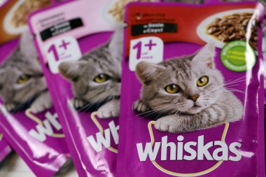 KHARKIV, UKRAINE - FEBRUARY 06, 2021: Whiskas branded cat pet food purple packages close up. Whiskas is a global brand of cat food produced by the American company Mars, Inc