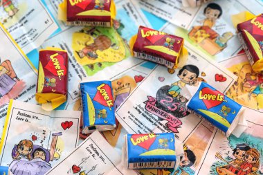 TERNOPIL, UKRAINE - JUNE 23, 2022: Love is - turkish bubble gum from 1990s popular in russian region. Various flavors of Love is chewing gum with liners about love in pile
