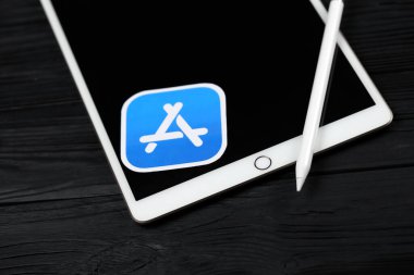 KHARKIV, UKRAINE - 27 Ocak 2021: Yepyeni Apple iPad ve Apple kalem ve siyah arkaplanda mavi uygulama mağaza logosu. Apple Inc. merkezi Kaliforniya 'da bulunan bir Amerikan teknoloji şirketidir.