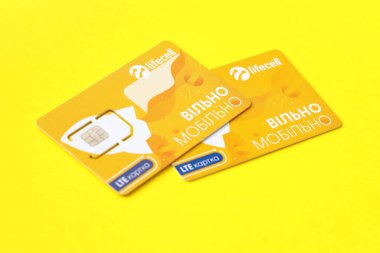 TERNOPIL, UKRAINE - 5 Temmuz 2022: Sarı arka planda ücretsiz sözleşmeli Lifecell yeni simülasyon kartı. Lifecell Ukraynalı cep telefonu operatörü ve kablosuz internet bağlantısı sağlayıcısı