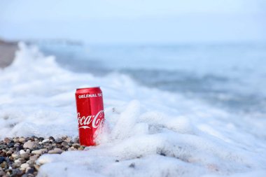 ANTALYA, TURKEY - 18 Mayıs 2021: Orijinal Coca Cola kırmızı teneke kutu deniz kıyısına yakın küçük yuvarlak çakıl taşları üzerinde yatar. Türk plaj taşları üzerinde Coca-Cola