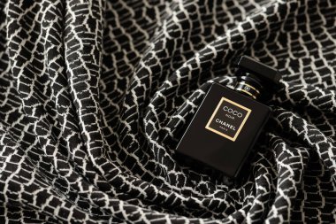 TERNOPIL, UKRAINE - SEPTEMBER 2, 2022 Coco Noir Chanel Paris worldwide famous french perfume black bottle on old plaid with monochrome pattern