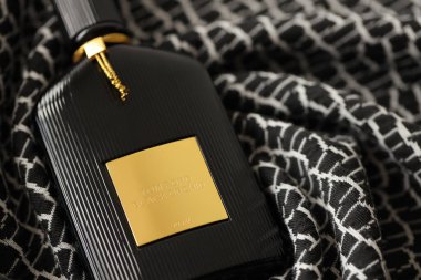 TERNOPIL, UKRAINE - SEPTEMBER 2, 2022 Tom Ford Black Orchid unisex perfume bottle on dark plaid in monochrome colors