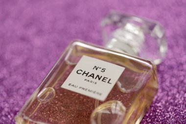 TERNOPIL, UKRAINE - SEPTEMBER 2, 2022 Chanel Number 5 Eau Premiere worldwide famous french perfume bottle on shiny glitter background in pink and purple colors