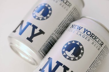 TERNOPIL, UKRAINE - JULY 18, 2022 Two cans of New Yorker fine lager beer with original logo and design on white paper background surface