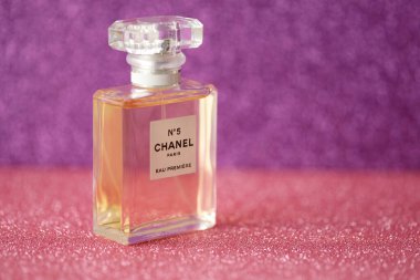 TERNOPIL, UKRAINE - SEPTEMBER 2, 2022 Chanel Number 5 Eau Premiere worldwide famous french perfume bottle on shiny glitter background in pink and purple colors