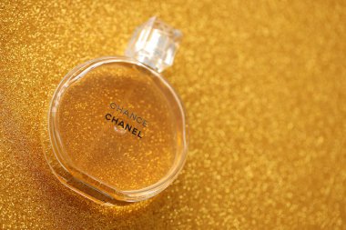 TERNOPIL, UKRAINE - SEPTEMBER 2, 2022 Chanel Chance worldwide famous french perfume bottle on shiny glitter background in golden and yellow colors