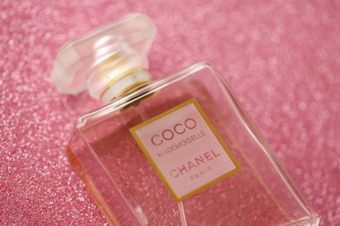 TERNOPIL, UKRAINE - SEPTEMBER 2, 2022 Coco Mademoiselle Chanel Paris worldwide famous french perfume bottle on shiny glitter background in purple and pink colors