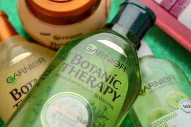 TERNOPIL, UKRAINE - SEPTEMBER 2, 2022 Bottle of Garnier Botanic Therapy Green Tea Shampoo among another Garnier company products close up
