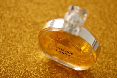 TERNOPIL, UKRAINE - SEPTEMBER 2, 2022 Chanel Chance worldwide famous french perfume bottle on shiny glitter background in golden and yellow colors