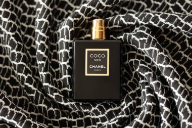 TERNOPIL, UKRAINE - SEPTEMBER 2, 2022 Coco Noir Chanel Paris worldwide famous french perfume black bottle on old plaid with monochrome pattern