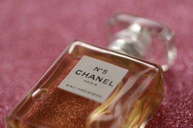 TERNOPIL, UKRAINE - SEPTEMBER 2, 2022 Chanel Number 5 Eau Premiere worldwide famous french perfume bottle on shiny glitter background in pink and purple colors