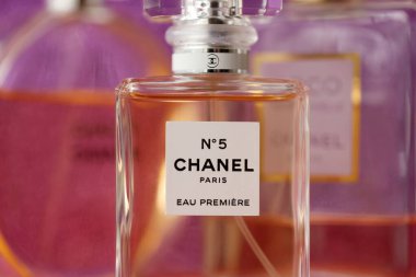 TERNOPIL, UKRAINE - SEPTEMBER 2, 2022 Chanel Number 5 Eau Premiere worldwide famous french perfume bottle among other perfumes on shiny glitter background in purple and pink colors