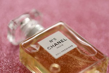 TERNOPIL, UKRAINE - SEPTEMBER 2, 2022 Chanel Number 5 Eau Premiere worldwide famous french perfume bottle on shiny glitter background in pink and purple colors