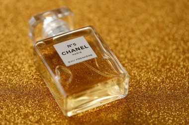 TERNOPIL, UKRAINE - SEPTEMBER 2, 2022 Chanel Number 5 Eau Premiere worldwide famous french perfume bottle on shiny glitter background in golden and yellow colors