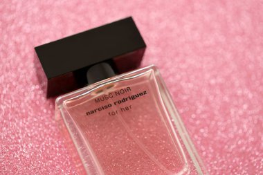 TERNOPIL, UKRAINE - SEPTEMBER 2, 2022 Narciso Rodriguez Musc Noir perfume bottle on shiny glitter background in pink and purple colors