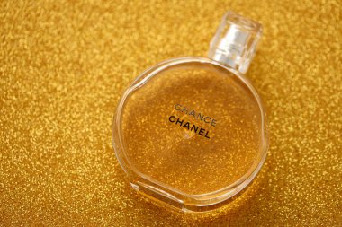 TERNOPIL, UKRAINE - SEPTEMBER 2, 2022 Chanel Chance worldwide famous french perfume bottle on shiny glitter background in golden and yellow colors