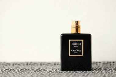 TERNOPIL, UKRAINE - SEPTEMBER 2, 2022 Coco Noir Chanel Paris worldwide famous french perfume black bottle on old plaid with monochrome pattern