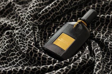 TERNOPIL, UKRAINE - SEPTEMBER 2, 2022 Tom Ford Black Orchid unisex perfume bottle on dark plaid in monochrome colors