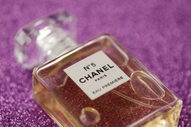 TERNOPIL, UKRAINE - SEPTEMBER 2, 2022 Chanel Number 5 Eau Premiere worldwide famous french perfume bottle on shiny glitter background in pink and purple colors