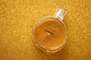 TERNOPIL, UKRAINE - SEPTEMBER 2, 2022 Chanel Chance worldwide famous french perfume bottle on shiny glitter background in golden and yellow colors