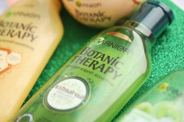 TERNOPIL, UKRAINE - SEPTEMBER 2, 2022 Bottle of Garnier Botanic Therapy Green Tea Shampoo among another Garnier company products close up