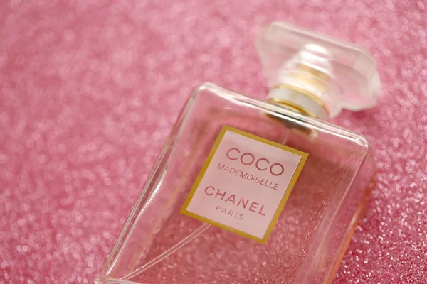 TERNOPIL, UKRAINE - SEPTEMBER 2, 2022 Coco Mademoiselle Chanel Paris worldwide famous french perfume bottle on shiny glitter background in purple and pink colors