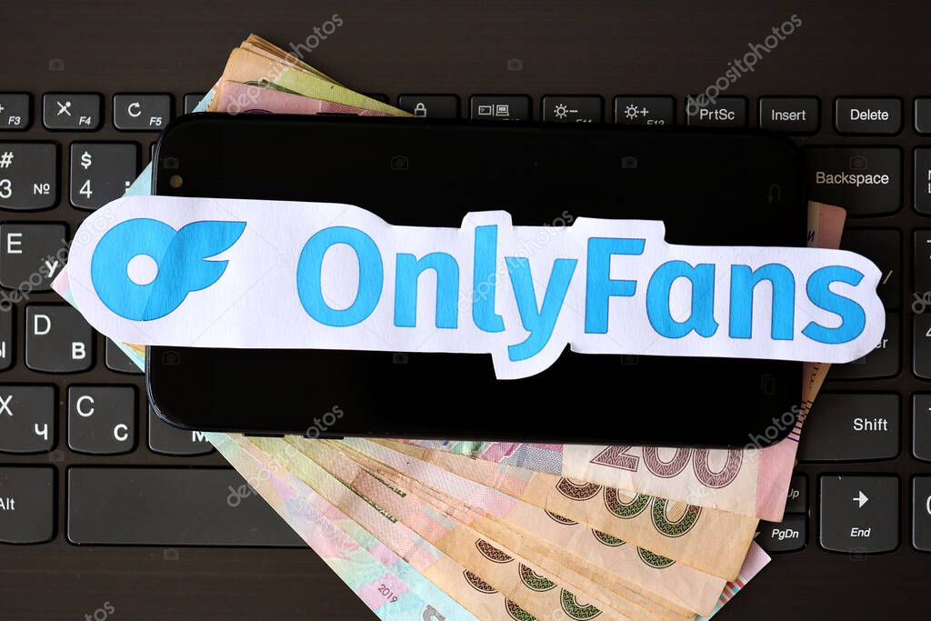 TERNOPIL, UKRAINE - SEPTEMBER 6, 2022 Onlyfans paper logotype on bunch of ukrainian hryvnias bills lies on black laptop keyboard buttons