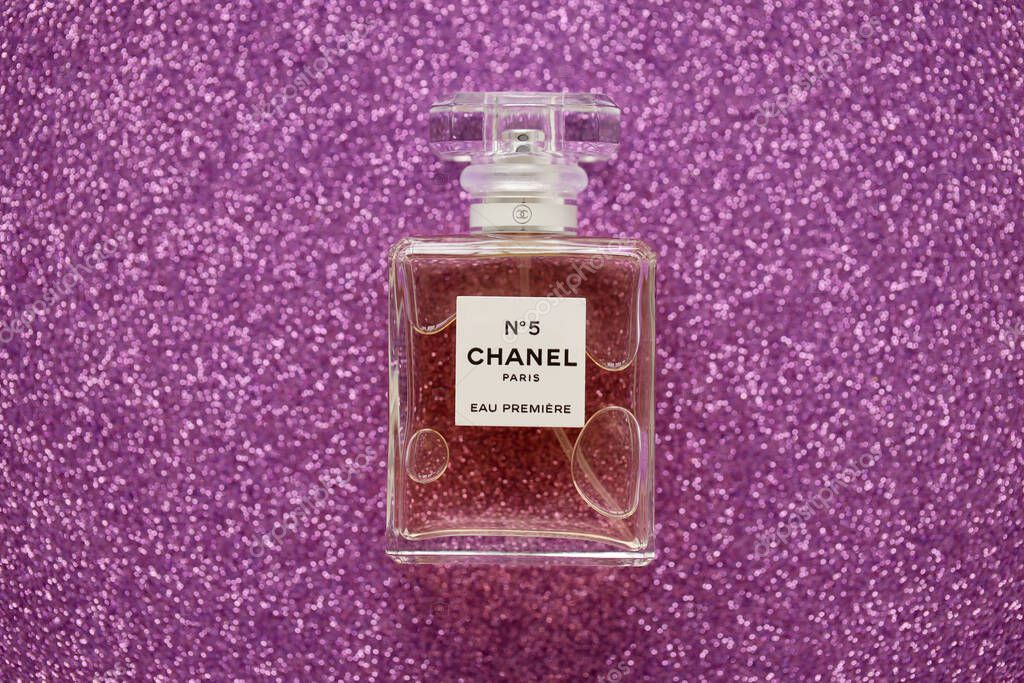 TERNOPIL, UKRAINE - SEPTEMBER 2, 2022 Chanel Number 5 Eau Premiere worldwide famous french perfume bottle on shiny glitter background in pink and purple colors
