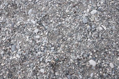 Deniz kıyısındaki kumsaldan çakıl taşlarının dokusu. Deniz kıyısından çok sayıda çakıl taşı