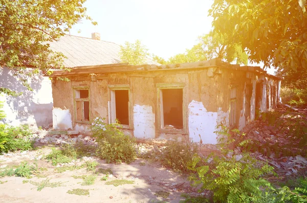 Collapsed industrial building in daytime. Disaster scene full of debris, broken bricks and damaged residental house. Concept of war action aftermath or building demolition