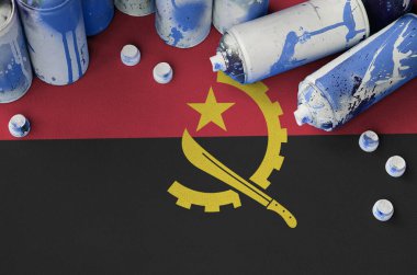 Angola bayrağı ve birkaç kullanılmış sprey sprey boya kutusu. Sokak sanatı kültürü kavramı, vandalizm sorunları
