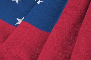 Büyük kıvrımlı Samoa bayrağı stüdyo ışıklarının altında sallanıyor. Resmi semboller ve renkler kumaş pankartıyla