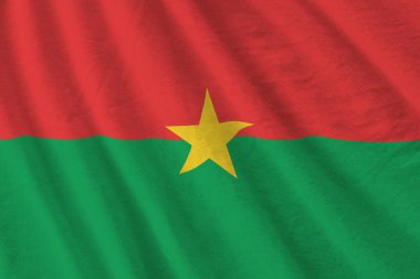 Büyük kıvrımlı Burkina Faso bayrağı stüdyo ışıklarının altında sallanıyor. Resmi semboller ve renkler kumaş pankartıyla