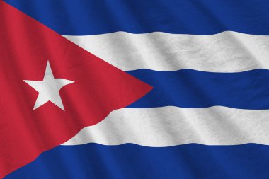 Büyük kıvrımlı Küba bayrağı stüdyo ışıklarının altında sallanıyor. Resmi semboller ve renkler kumaş pankartıyla