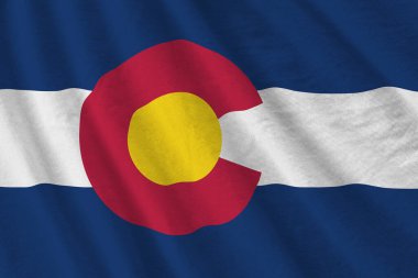 Colorado eyalet bayrağı. Stüdyo ışıklarının altında büyük kıvrımlar sallanıyor. Resmi semboller ve renkler kumaş pankartıyla