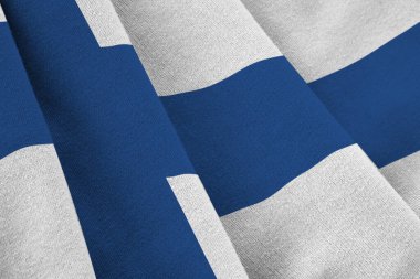 Stüdyo ışıklarının altında büyük kıvrımlar sallanan Finlandiya bayrağı. Resmi semboller ve renkler kumaş pankartıyla