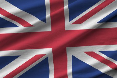 Büyük kıvrımlı İngiltere bayrağı stüdyo ışıklarının altında sallanıyor. Resmi semboller ve renkler kumaş pankartıyla