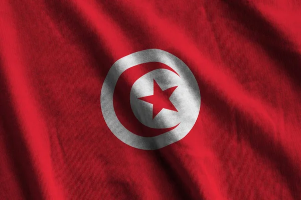 在室内的演播室灯光下 巨大的褶皱摇曳着突尼斯国旗 织物横幅中的官方符号和颜色 — 图库照片